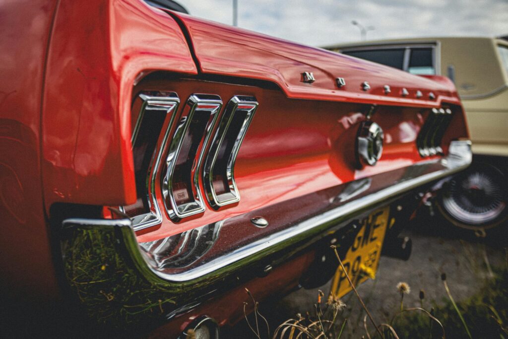 Close-up view of a classic red Ford Mustang's tail lights showcasing vintage car design.